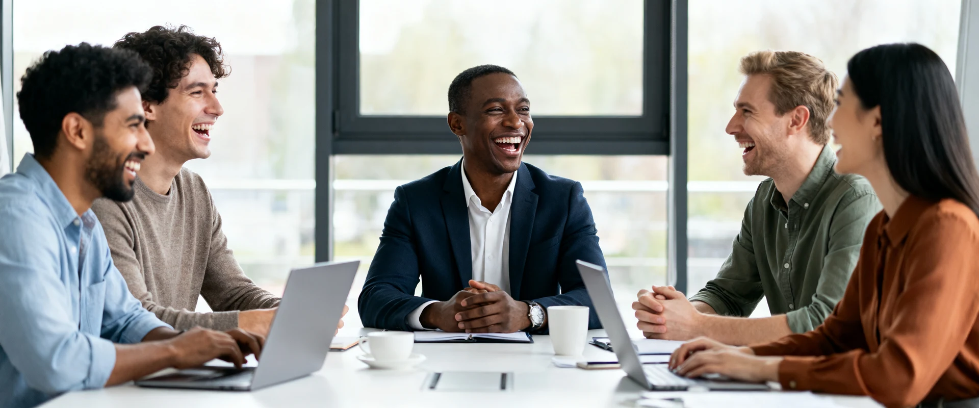 Equipe diversa de colegas de trabalho sorrindo e colaborando em reunião casual ao redor de mesa moderna de escritório, fotografia editorial ultra-realista com luz natural, momento autêntico e espontâneo capturado em alta resolução.