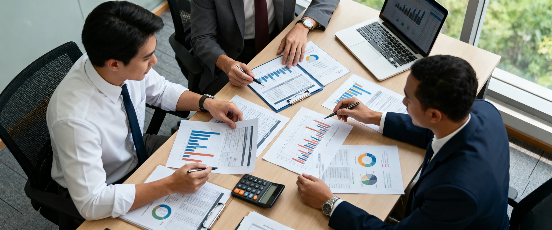 Fotografia editorial ultra-realista de equipe de negócios diversa analisando gráficos financeiros e documentos de projeto em mesa de conferência, com laptop, calculadora e planilhas, luz natural de janela, foco nítido e detalhes cristalinos em alta resolução.